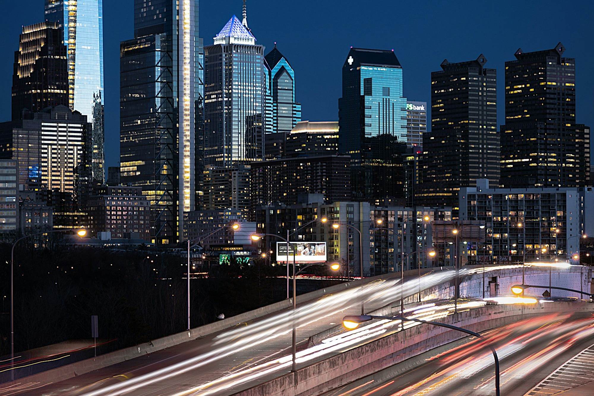 Philadelphia airport transfer: Philadelphia's skyline at night with light trails on the expressway