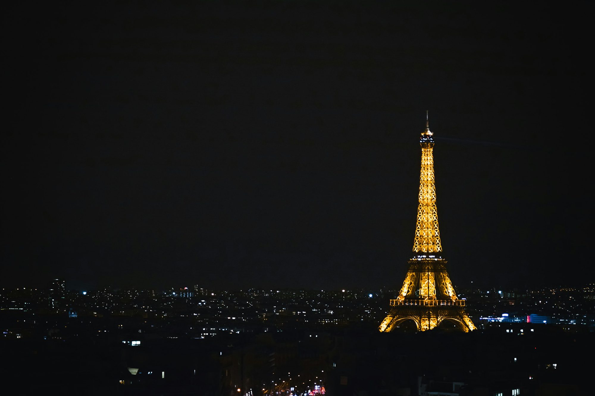 The Eiffel Tower lit up above the Paris skyline at night